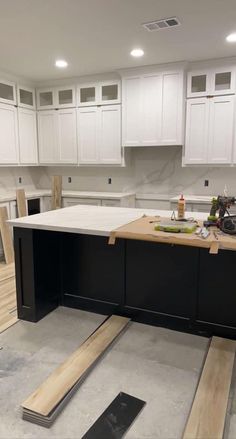 an unfinished kitchen with white cabinets and wood flooring in the process of remodeling