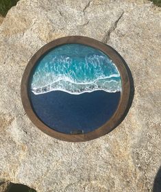 an image of the ocean seen through a round hole in a rock wall or floor