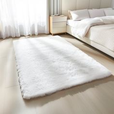 a large white rug on the floor in a bedroom