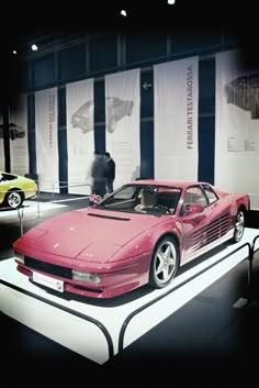 a pink sports car on display in a museum