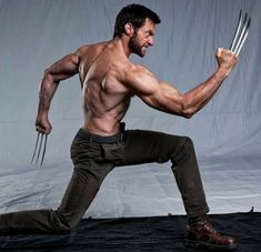 a man is posing for the camera with his claws in one hand and holding two knives in the other