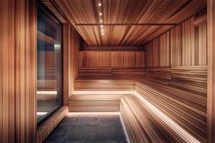 an empty sauna with wooden walls and flooring in a room that is lit by lights