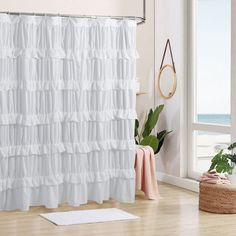 a white shower curtain with ruffles hanging from it's side in a bathroom