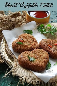 three fried vegetable cutlets on a plate with ketchup