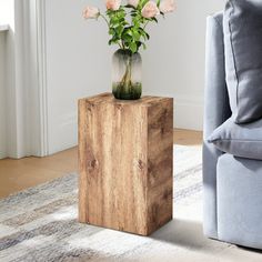 a vase filled with flowers sitting on top of a wooden table next to a couch