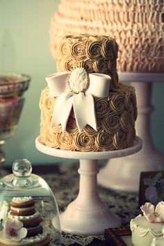 a three tiered cake sitting on top of a table next to other desserts