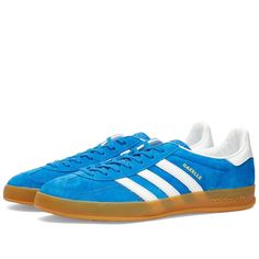 adidas reintroduces its iconic Gazelle Indoor trainers from 1979 this season. Arriving in a blue colourway, they have all the details that football fans, indie rockers and sneakerheads have loved for decades. From its soft suede and a durable leather lining- which comes together on a gum rubber outsole. Then, they’re signed off at the side wall with its signature Three Stripes..Suede Uppers.Rubber Outsole.Three Stripes on Side Wall.Trefoil on Tongue and Heel Tab Blue Low-top Sneakers With Three Stripes Branding, Blue Leather Sneakers With Three Stripes, Blue Adidas Sneakers With Vulcanized Sole, Adidas Blue Sneakers With Vulcanized Sole, Blue Sneakers With Three Stripes Branding, Blue Low-top Sneakers With Three Stripes, Blue Skate Shoes With Three Stripes For Streetwear, Blue Skate Shoes With Three Stripes And Round Toe, Blue Three Stripes Skate Shoes With Round Toe