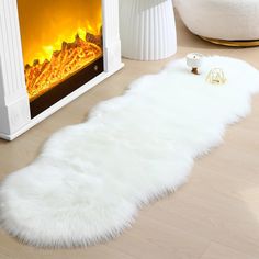 a white sheepskin rug on the floor next to a fireplace