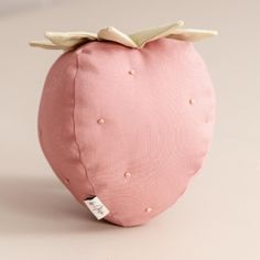 a pink stuffed strawberry sitting on top of a table