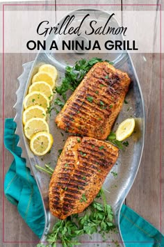 grilled salmon on a serving platter with lemons and parsley garnish