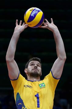 a man is reaching up to hit a volleyball