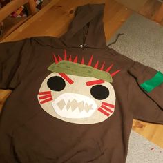 a brown hoodie with an angry face on it