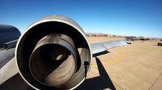 an airplane is parked on the tarmac with it's tail end showing up