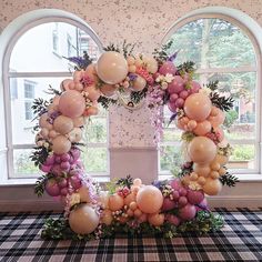 the balloon arch is decorated with flowers and balloons