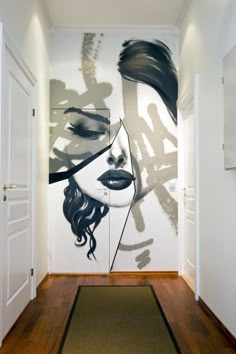 a painting on the wall of a woman's face is shown in this hallway