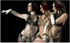 three women dressed in costumes are posing for the camera with their hands on their hips