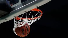 a basketball is going through the net to dunk it