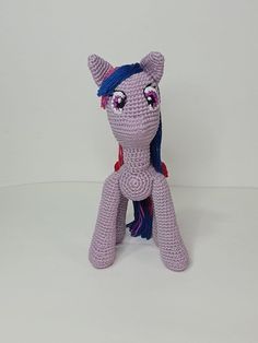 a crocheted pony sitting on top of a white table