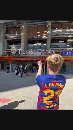 a young boy is flying a kite in front of the arena at an indoor stadium