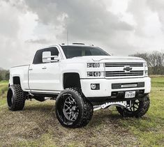 a white truck parked on top of a grass covered field