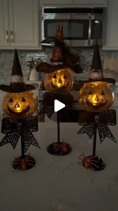 three lighted pumpkins sitting on top of a kitchen counter