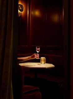 a person holding a wine glass over a table