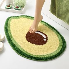 a person standing on top of a rug with an avocado design on it