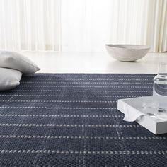 a living room with a blue rug and water bottle on the floor next to it