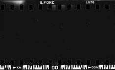 an old film strip with black and white lines on it's edges, in front of a dark background