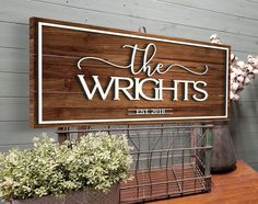 a wooden sign that says the wrights on it next to some potted plants