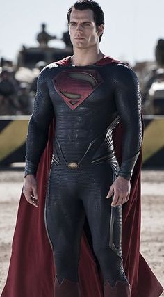 a man in a superman costume standing on the beach