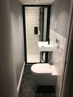 a white toilet sitting next to a sink in a bathroom