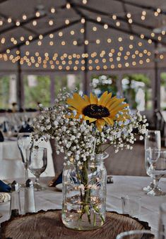 a sunflower in a vase sitting on top of a table