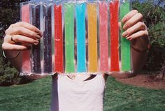 a woman holding up an assortment of colorful candy bars