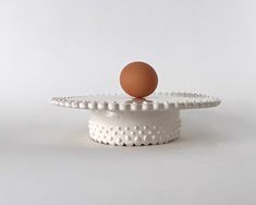 an egg is sitting on top of a cake stand