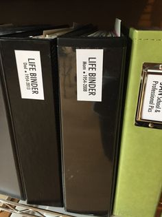 two black binders sitting next to each other on a shelf