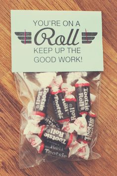 a bag filled with candy sitting on top of a wooden table next to a sign