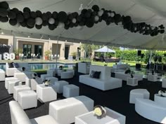 an outdoor event with white couches and chairs