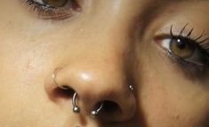 a woman with piercings on her nose looking at the camera