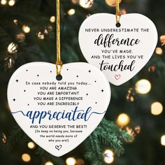 two white ceramic heart ornaments hanging from a christmas tree