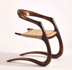 a wooden chair with a woven seat on the back and armrests that are bent to one side