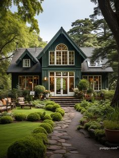 a green house with lots of windows and plants on the front lawn, surrounded by greenery