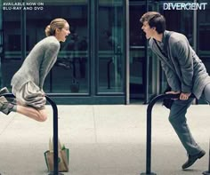 a man and woman are jumping over the railings in front of an office building