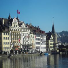 several buildings line the water in front of a bridge