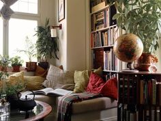 a living room filled with lots of books and plants