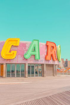 a large sign that is on the side of a building in front of a ferris wheel