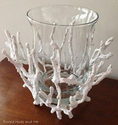 a glass vase sitting on top of a wooden table next to a white tree branch