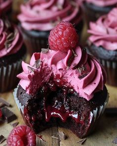 chocolate cupcakes with raspberry frosting and fresh raspberries on top