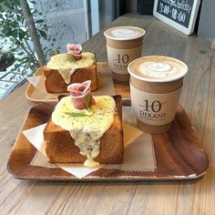 three pieces of bread and two cups of coffee on a table