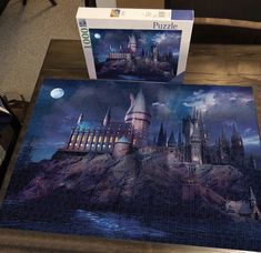 a puzzle is sitting on a table next to a box with the image of hogwart's castle